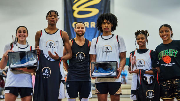 Stephen Curry poses for a picture with kids at his basketball camp.